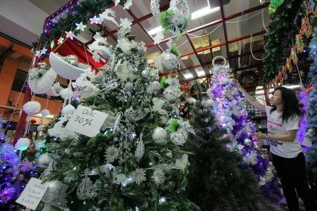 Warga memilih pohon Natal di salah satu stan di Pasar Atum, Surabaya, Jawa Timur, Selasa (20/12). Foto oleh Didik Suhartono/ANTARA 