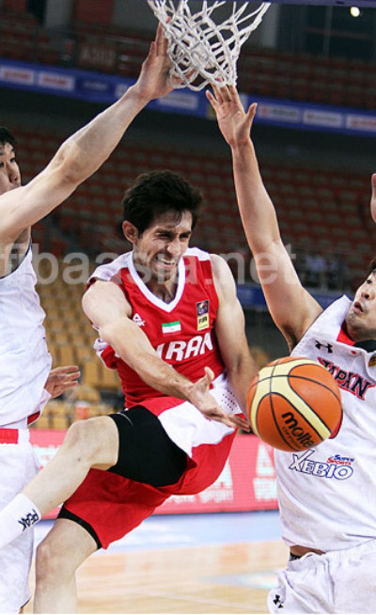 Iran's Sajjad Mashayekki (C) drives against two defenders and issues a drop pass to a teammate. Photo from fibaasia.net
