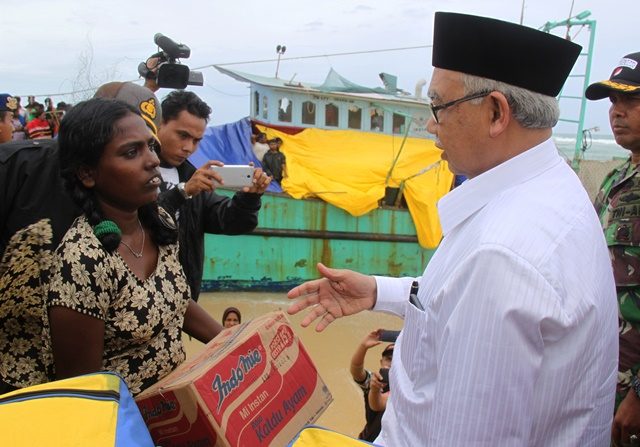 SERAHKAN BANTUAN. Gubernur Aceh Zaini Abdullah (kanan) menyerahkan bantuan logistik kepada salah seorang imigran Sri Lanka yang terdampar di Pantai Pulau Kapuk, Aceh Besar, Aceh, Jumat, 17 Juni. Foto oleh Ampelsa/ANTARA 