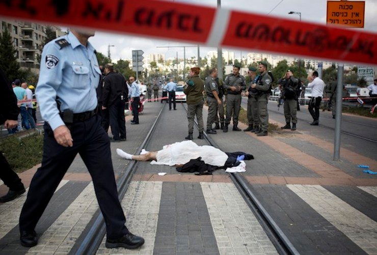 GUNNED DOWN. Israeli police near the body of a Palestinian man, identified as Ibrahim al-Akari, after he was shot and killed on the Light Rail trolley system in East Jerusalem, 05 November 2014. Tali Mayer/EPA