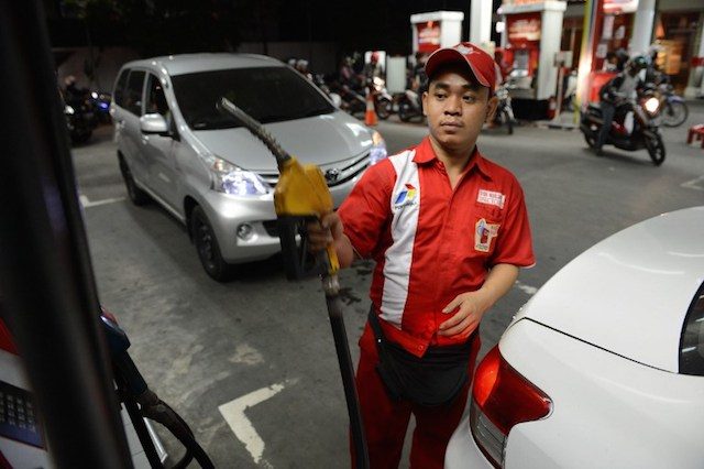 A fuel attendant at the state-energy firm, Pertamina fuel station prepares to fill up motorists in Jakarta on November 17, 2014 