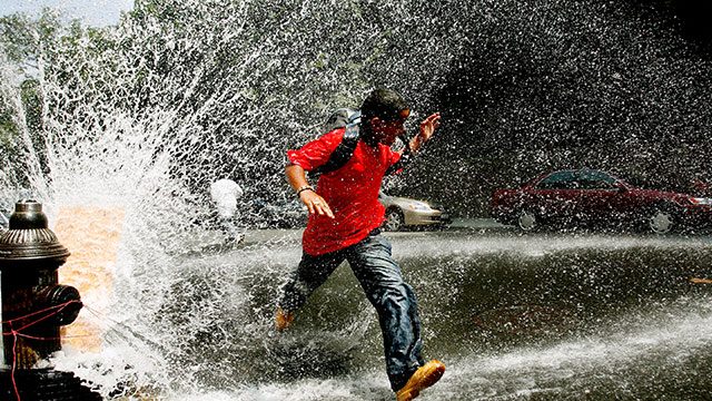 RELIEF. A young boy runs through water being sprayed by an open fire hydrant in the Bronx, New York, in this photo taken in 2006. File photo by Justin Lane/EPA 