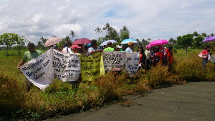 PROTEST. MacArthur townspeople with other civil society members and partners of Alyansa Tigil Mina hold a rally in front of an illegal black sand mining site in Maya village. All photos by Denisse Fontanilla