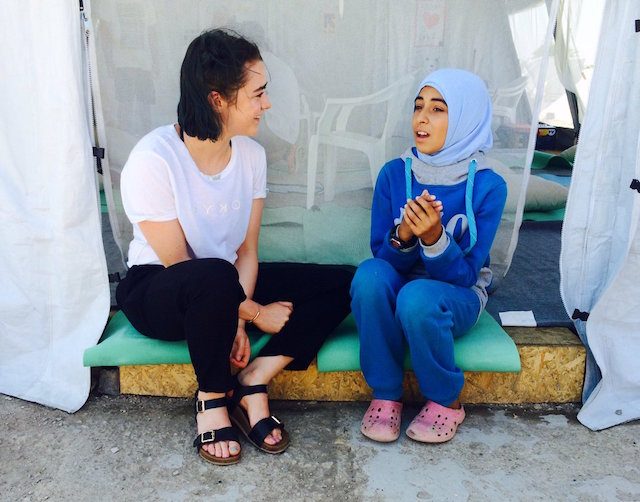 Maisie Williams mendengarkan kisah Haya, 13 tahun, yang ingin menjadi aktor. Ia adalah satu dari 57 ribu pengungsi Suriah di Yunani. Foto: IRC 
