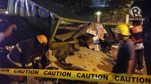 PINNED DOWN. A wall from the Two Serendra unit fell onto a parked Abenson truck below, killing 3 people onboard the truck. File photo by Rappler