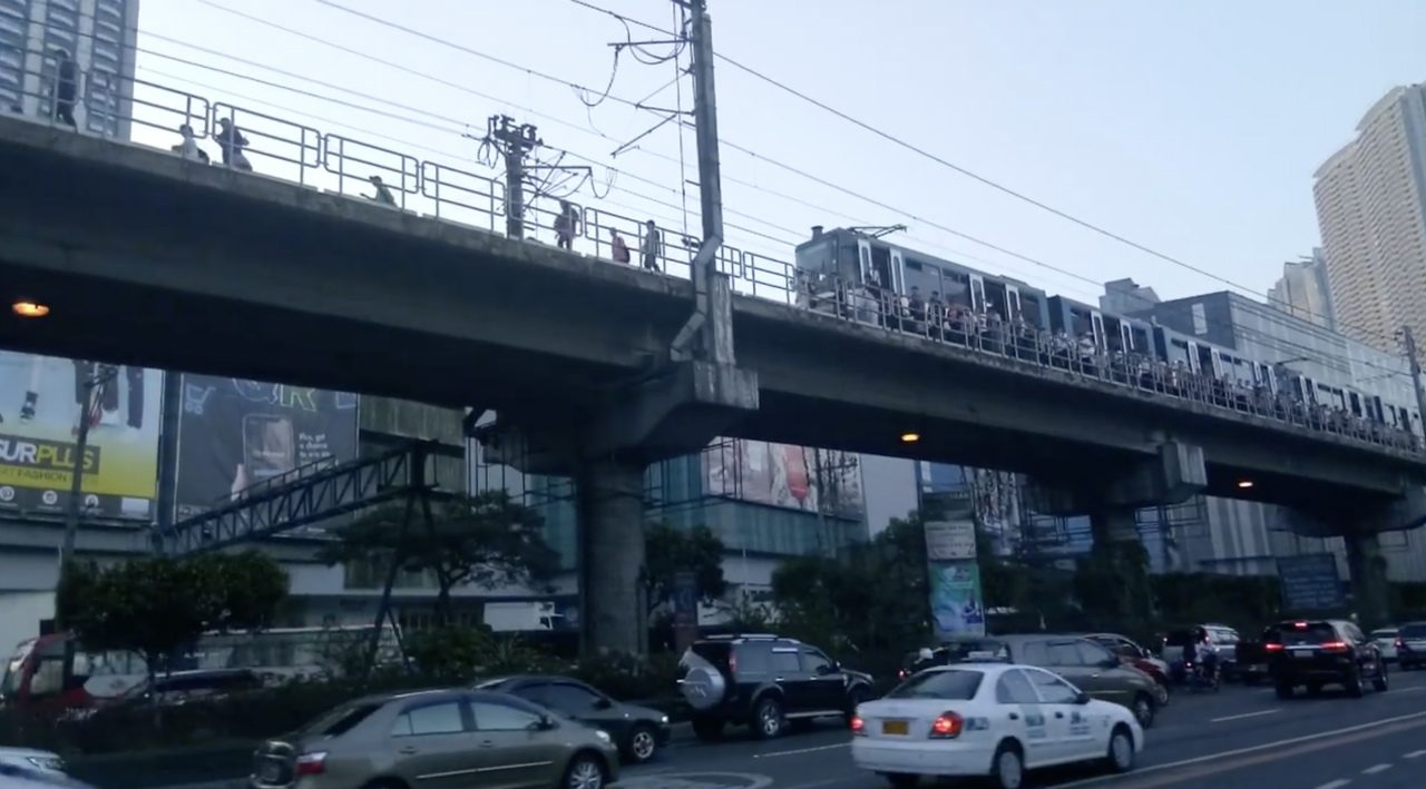Passengers walk along MRT3 tracks due to braking failure