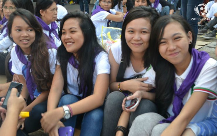 YOUTH IDOL. Nancy Piquero (leftmost) sits along Quirino avenue with her friends while waiting for the pontiff.