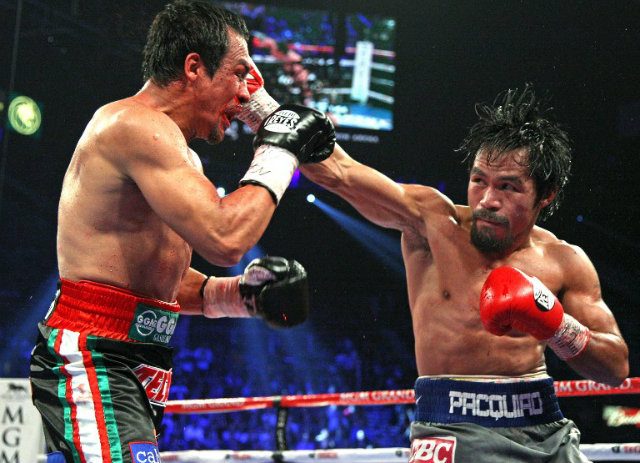PUNCH. Manny Pacquiao delivers a hard punch on Juan Manuel Marquez. Photo by John Gurzinski/AFP 