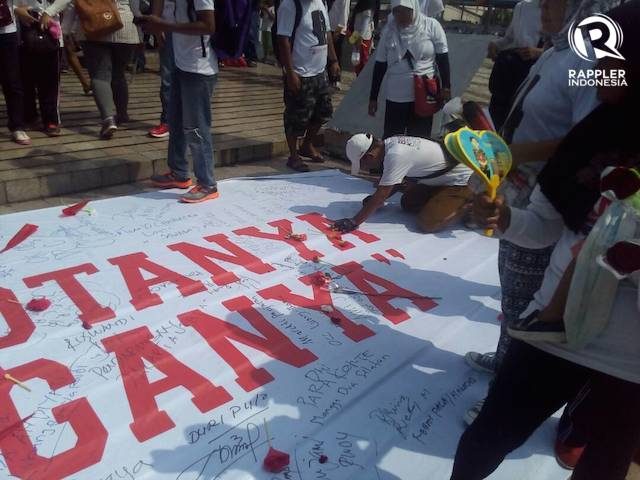 Peserta aksi 'Sejuta Bunga Untuk Anies-Sandi' berkumpul di Bundarah HI. Mereka menandatangani spanduk bertuliskan "Jakarta, Majulah Kotanya dan Bahagialah Kotanya". Foto oleh Yanwar Arifin/Rappler. 