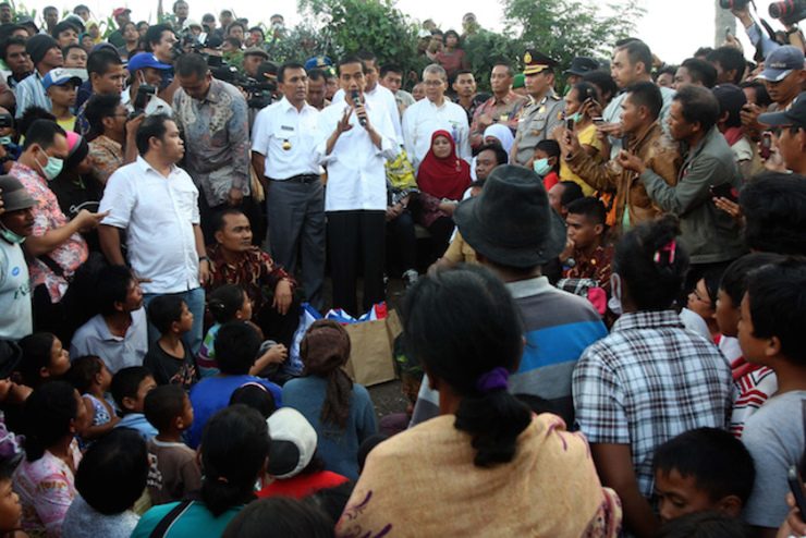 FIRST TRIP. President Joko Widodo (C) speaks to villagers who fled their houses after the eruption of Mount Sinabung at a refugee camp in Gurukinayan village, Karo, North Sumatra, on October 29, 2014. Photo by Dedi Sahputra/EPA 