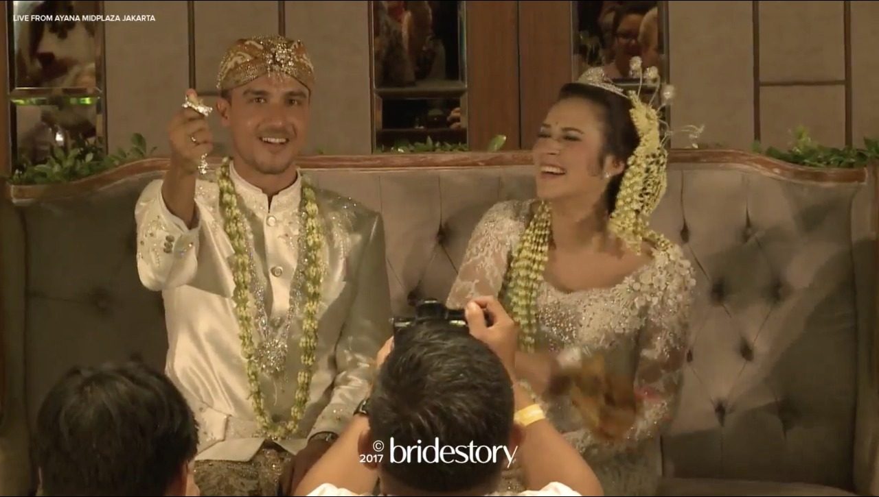 Raisa tertawa lepas menjalani prosesi pernikahan dengan adat Sunda, Minggu (3/9). Foto oleh Bridestory 