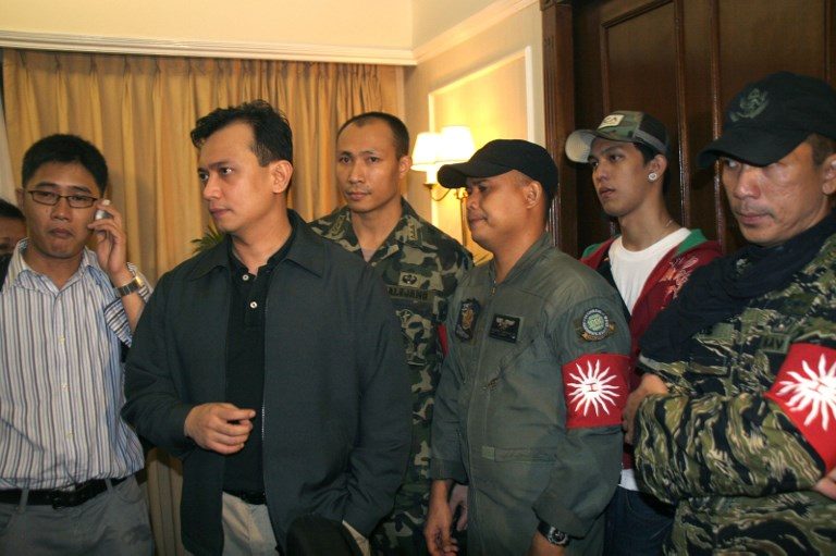 SECOND TIME. Senator Antonio Trillanes IV joined by rebel officers and civilian supporters inside a hotel room after announcing their surrender while government security forces assault the luxury Manila Peninsula in Makati,  November 29, 2007. File photo by Jason Gutierrez    