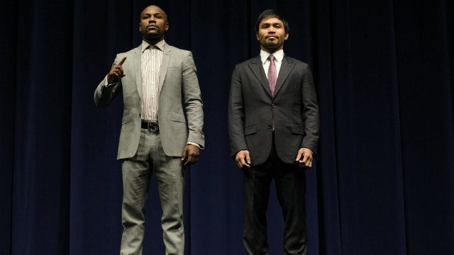 Floyd Mayweather Jr (L) and Manny Pacquiao pose on stage. Photo by Chris Farina - Top Rank 