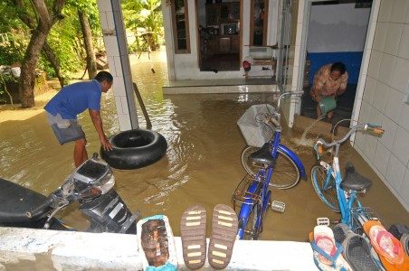 Sejumlah warga membersihkan air yang masuk ke dalam rumahnya di Desa Sidaharja, Kabupaten Tegal, Jawa Tengah, Rabu (4/1). Foto oleh Oky Lukmansyah/tANTARA 