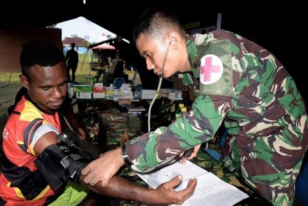 Seorang dokter dari Satgas Pamtas Yonif 122/TS memeriksa warga Papua Nugini (PNG) saat pameran dan pelayanan kesehatan di perbatasan RI-PNG, Skouw, Papua, Selasa (4/10). Pameran dan pelayanan kesehatan bagi warga negara Indonesia dan PNG di daerah perbatasan tersebut dalam rangka HUT ke-71 TNI. Foto oleh Indrayadi/ANTARA 