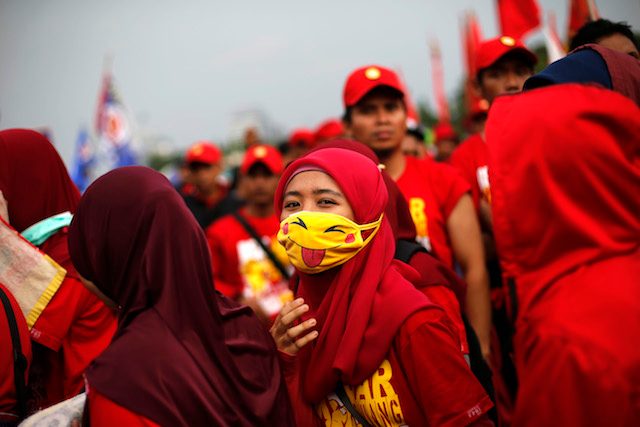 BURUH. Seorang pekerja Indonesia menggunakan masker pikachu dalam demonstrasi Hari Buruh Internasional di depan Istana Negara, 1 Mei 2014. Foto oleh Mast Irham/EPA 