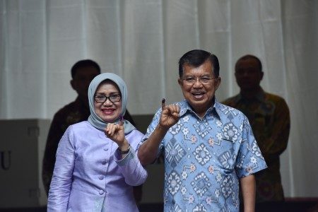 Wakil Presiden Jusuf Kalla bersama istri Mufidah Jusuf Kalla menunjukkan jari seusai memberikan suara pada Pilkada DKI Jakarta putaran kedua di TPS 3 Pulo, Kebayoran Baru, Jakarta, Rabu (19/4). Foto oleh Wahyu Putro/ANTARA   