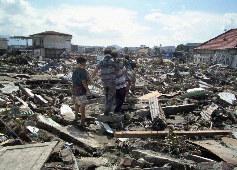 Residents of Banda Aceh carrying the body of a relative, a day after the tsunami hit.
