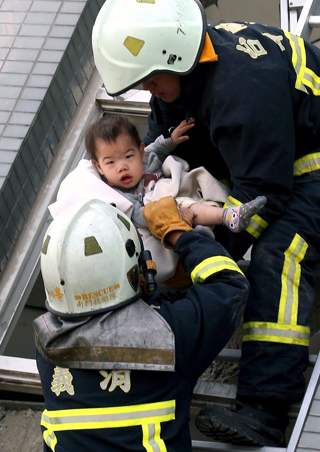 Pemadam kebakaran berhasil menyelamatkan seorang bayi dari gedung yang runtuh di kota Tainan, Taiwan pada Sabtu, 6 Februari 2016 akibat gempa berkekuatan 6,4 skala richter. Fot oleh Johnson Liu/EPA 