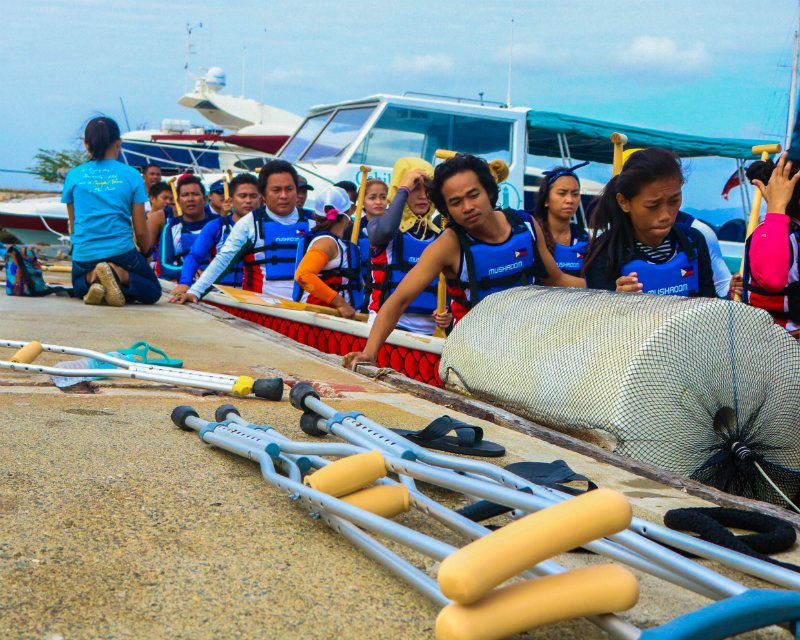 CRUTCHES TO PADDLES. As the paddlers board the dragonboat, they leave behind their crutches on the docking area in exchange for paddles and begin their extensive sea training. Photo by Richale Cabauatan  