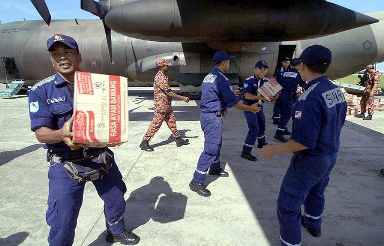 Malaysia sent its disaster rescue team to help. In this photo, they are seen helping Indonesian troops unload relief goods. 
