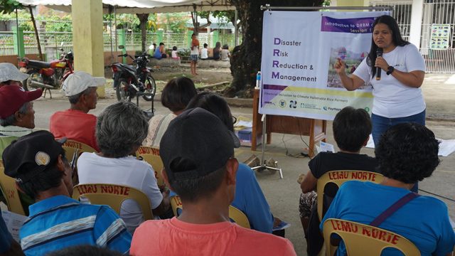 TEACHER. Ana Ria Barrera explains the concepts of disaster risk reduction to farmers affected by Typhoon Mangkhut during a community cash card distribution in Enrile, Cagayan with the support of Oxfam. Photo: Denvie Balidoy/Oxfam 