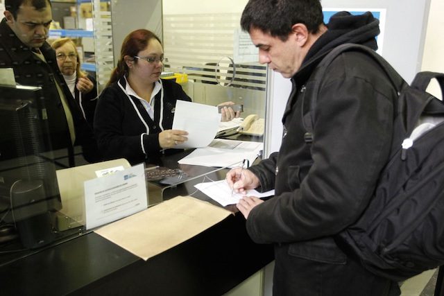 FIRST DIBS. The spokesman for the Association of Cannabis Studies in Uruguay, Juan Vaz (R), is the first domestic grower to register as a 'home grower', in the Marijuana growers registry at the central headquarters of Uruguay's Postal Service, in Montevideo, Uruguay, on 27 August 2014. Iván Franco/EPA