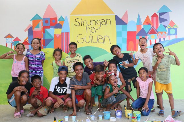 SIRUNGAN SA GUIUAN. Children artists of Guiuan take part in painting the murals of Sirungan ha Guiuan (Shelter of Guiuan) with messages of hope. Image courtesy UNICEF / IOM  