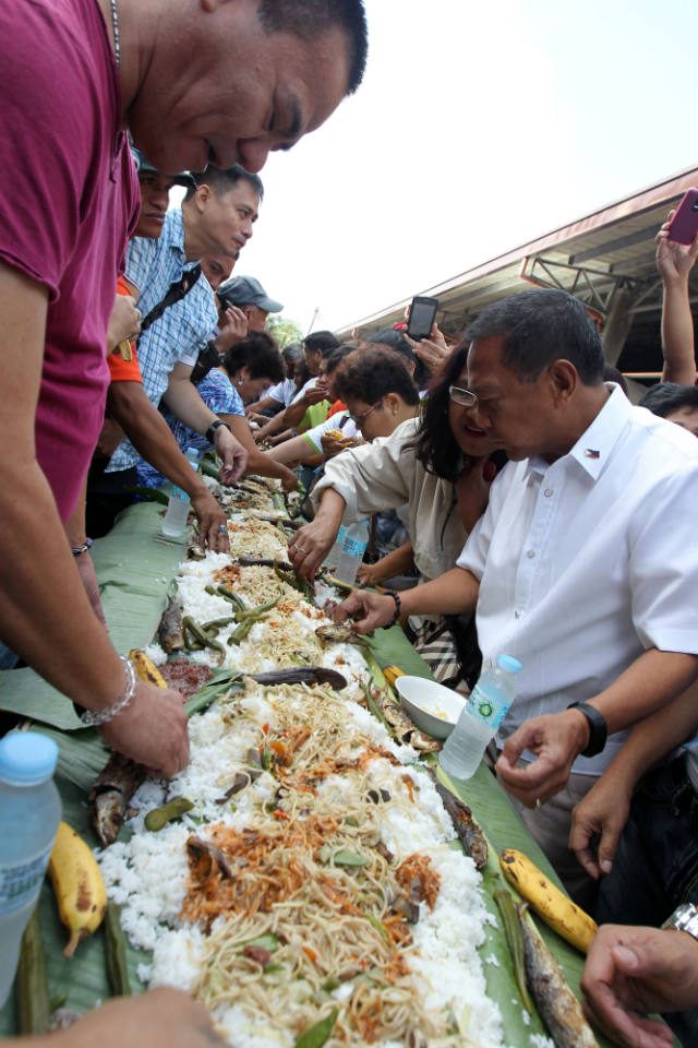 'ONE WITH MASSES.' R​esidents of ​Alfonso, Cavite​ share a meal with ​Vice President Jejomar C. Binay​ during the latter's visit to ​the Luksuhin Public Market on November 13. File photo from the Office of the Vice President