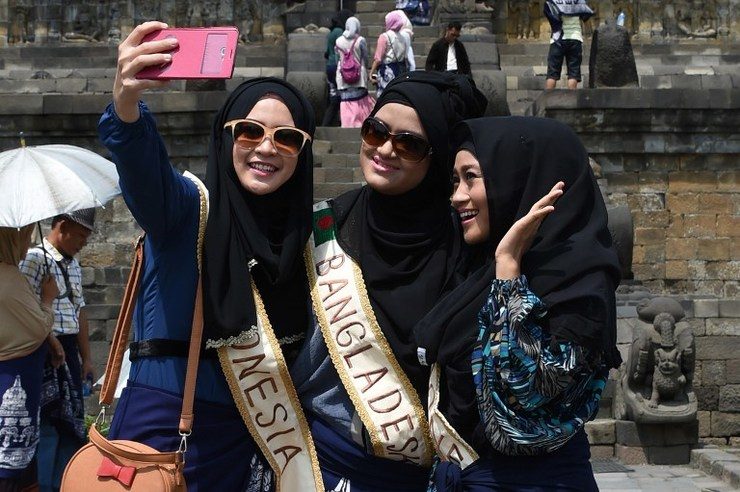 SELFIE TIME. Finalists of the 2014 World Muslimah Awards Siti Fathimah Junyanti (L) of Indonesia, Tarannum Tasmine (C) of Bangladesh and Lulu Susanti (R) of Indonesia have a picture together during a tour at the Borobudur temple complex in Magelang, Central Java, on November 17, 2014. Photo by Adek Berry/AFP
