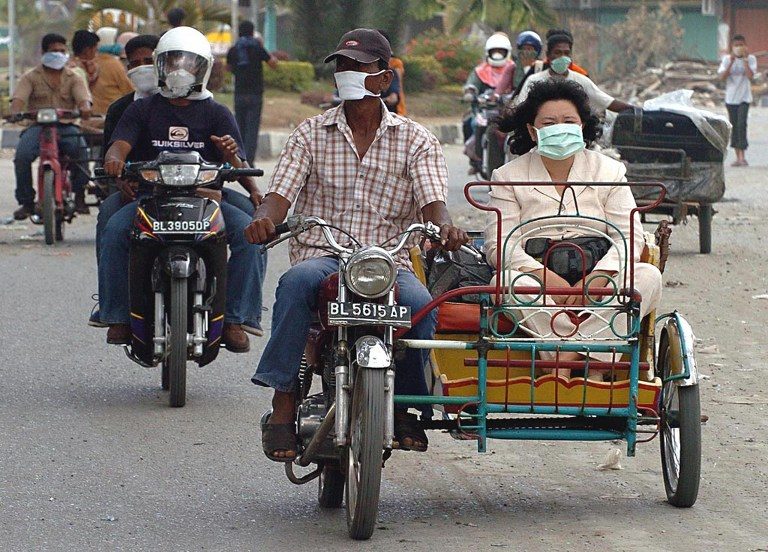 In Banda Aceh, survivors wear masks to avoid the smell of rotting corpses.
