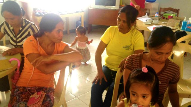LEADER. Milagros Bendahon (in yellow shirt) listens to a community member during a workshop. Photo by Jodesz Gavilan 