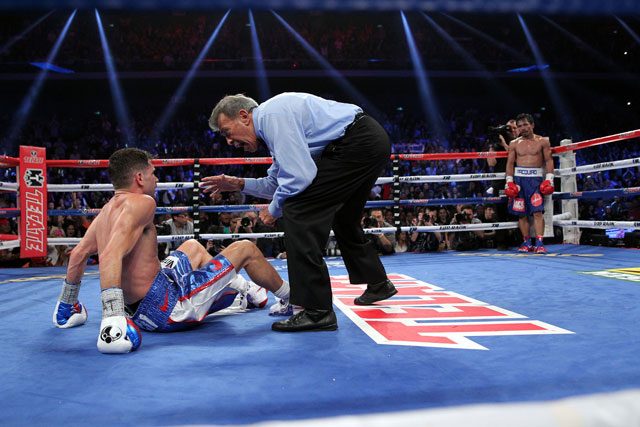 Pacquiao stands in the neutral corner as the referee checks on Algieri after getting knocked down. Photo by Chris Farina/Top Rank