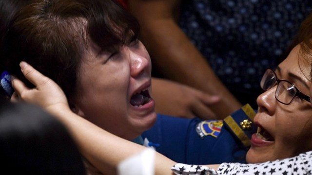Family members of passengers onboard the missing AirAsia flight react after watching news reports showing an unidentified body floating in the Java sea, inside the crisis-center set up at Juanda International Airport in Surabaya on December 30, 2014.  Photo by Manan Vatsyayana/AFP 