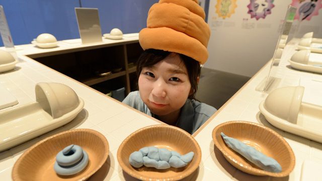 HELLO. A staff member wearing a poo-shaped hat poses at a toilet exhibition at the National Museum of Emerging Science and Innovation in Tokyo. Photo by Toru Yamanaka/ AFP