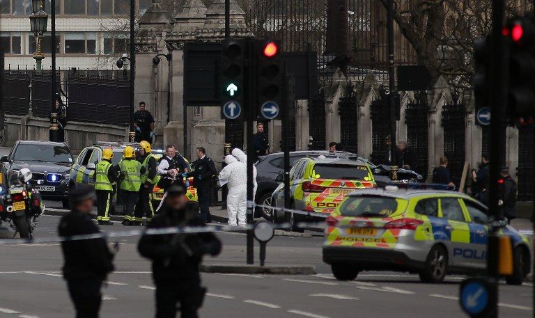 DITUTUP. Polisi bersenjata berdiri untuk mengamankan TKP peristiwa serangan teror terhadap Gedung Parlemen Inggris pada Rabu, 22 Maret. Akibat serangan teror itu sebanyak tiga orang tewas. Foto oleh Daniel Leal-Olivas/AFP 