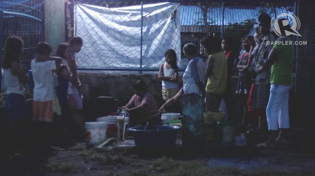 WAITING FOR WATER. Evacuees wait at 6 am to collect water from two water sources, a faucet and water pipe