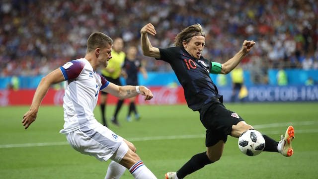 BLOK. Luka Modric dari Kroasia berusaha memblok bola dari Johann Gudmundsson dari Islandia. Foto dari FIFA.com 