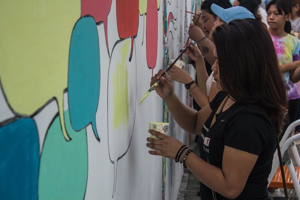 COMMUNITY EFFORT. Several volunteers take their paint brushes to help contribute to the mural. Photo courtesy of Paul Basco.   