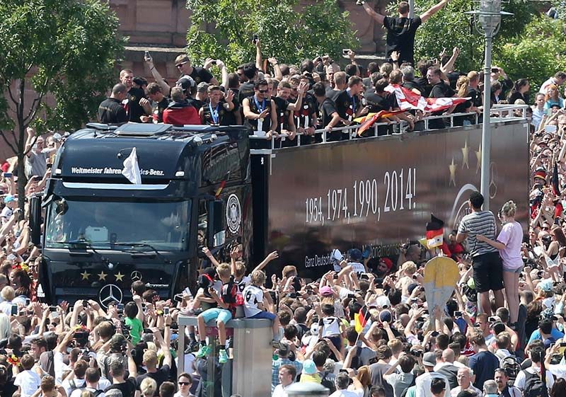 Crowds of cheering fans surround the bus carrying Germany's national football team on its way to the 'Fan Meile' at the Brandenburg Gate, Berlin. Photo by Wolfgang Kumm/EPA