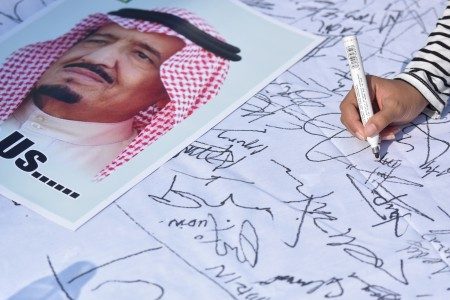 Warga membubuhkan tanda tangan didekat poster Raja Arab Saudi Salman bin Abdulaziz Al Saud ketika pelaksanaan Car Free Day di Bundaran HI Jakarta, Minggu (26/2). Foto oleh Wahyu Putro/ANTARA 