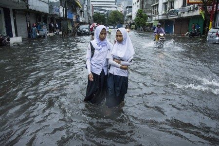 Pelajar berjalan melintasi air banjir di kawasan Sawah Besar, Jakarta, Selasa (21/2). Foto oleh Aprillio Akbar/ANTARA 
