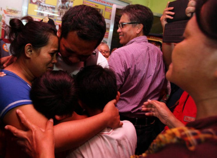 REUNITED. A captive policeman is reunited with his family after a simple welcoming ceremony by authorities for the policemen at the Kitcharao Elementary School in Agusan del Norte, Mindanao on July 29, 2014. Photo courtesy of the DILG