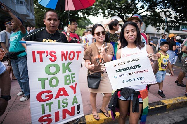 PROTESTS. An anti-LGBTQ+ protester holds a placard saying that to be gay is a sin. Photo by Martin San Diego/Rappler 