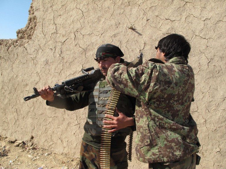 Besieged Afghan forces battle to flush out Taliban in key district