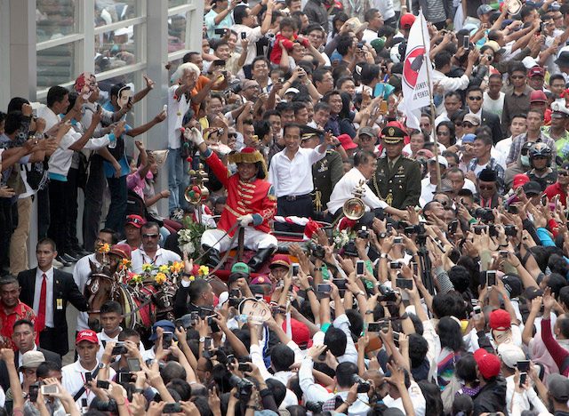 PRESIDENTIAL PARADE. Jokowi and Vice President Jusuf Kalla on board a horse-draw carriage making their way through tens of thousands of people. Photo by EPA