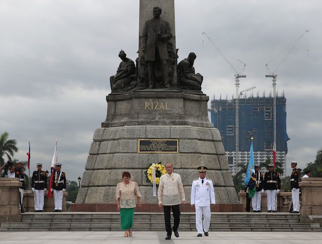 PHOTOBOMBING CONDO. President Benigno S. Aquino III leads the flag raising ceremonies for the commemoration of the 188th Anniversary of the Martyrdom of Jose Rizal at the Rizal National Monument in Rizal Park on December 30, 2014. At the back stands an unfinished condominium which as gained opposition among heritage advocates. Photo by Malacañang 