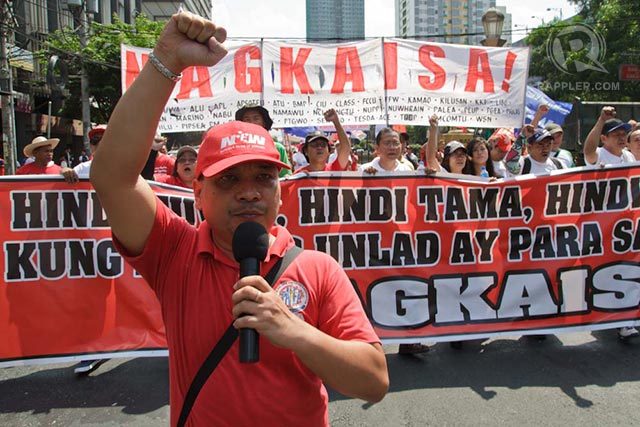 Workers wear ‘angry’ red shirts in Labor Day march