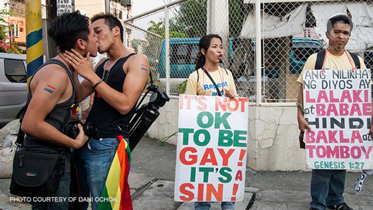 SINNERS VS. SAINTS? A gay couple kisses at the 2012 Pride March in front of anti-homosexual protestors. Photo courtesy of Dani Ochoa