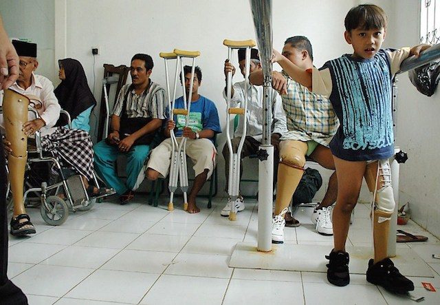 Meanwhile, those who suffered debilitating injuries began recovering. In this image, a child tries out his new artificial leg. 